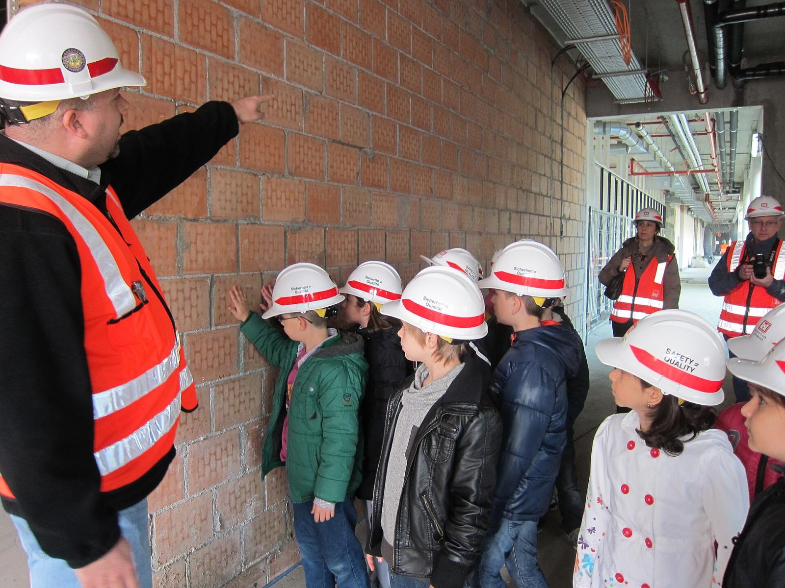 Construction team in safety equipment receiving a site briefing